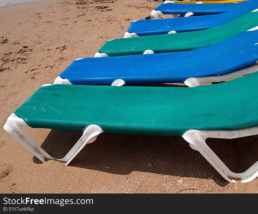 Summer Vacation Beach Line of sun beds by the water edge