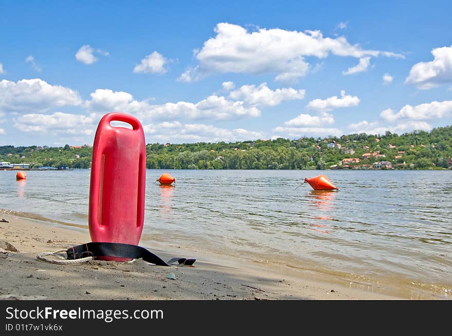 Lifeguard buoy in the sand next to river