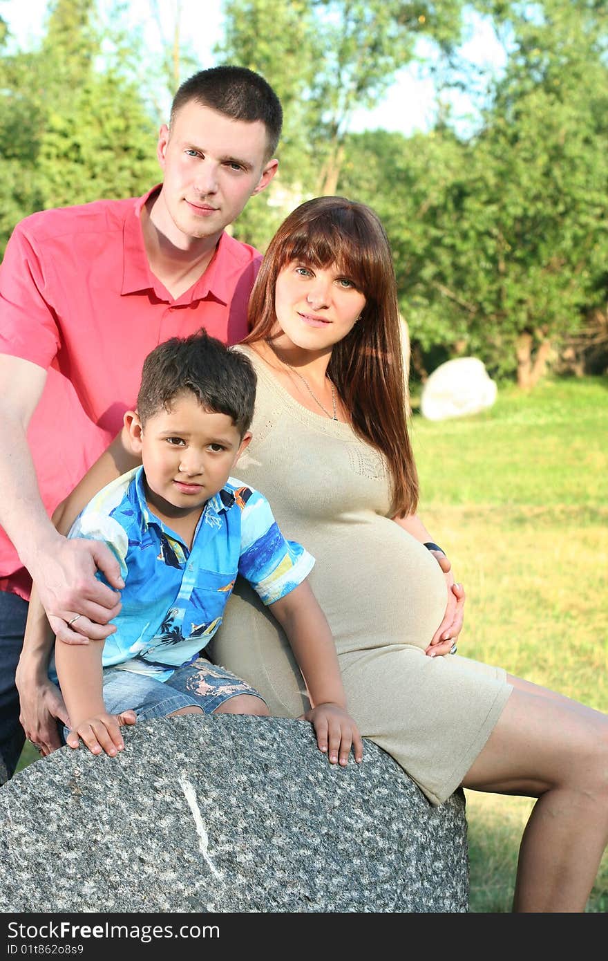 Happy young family relaxing in park. Happy young family relaxing in park