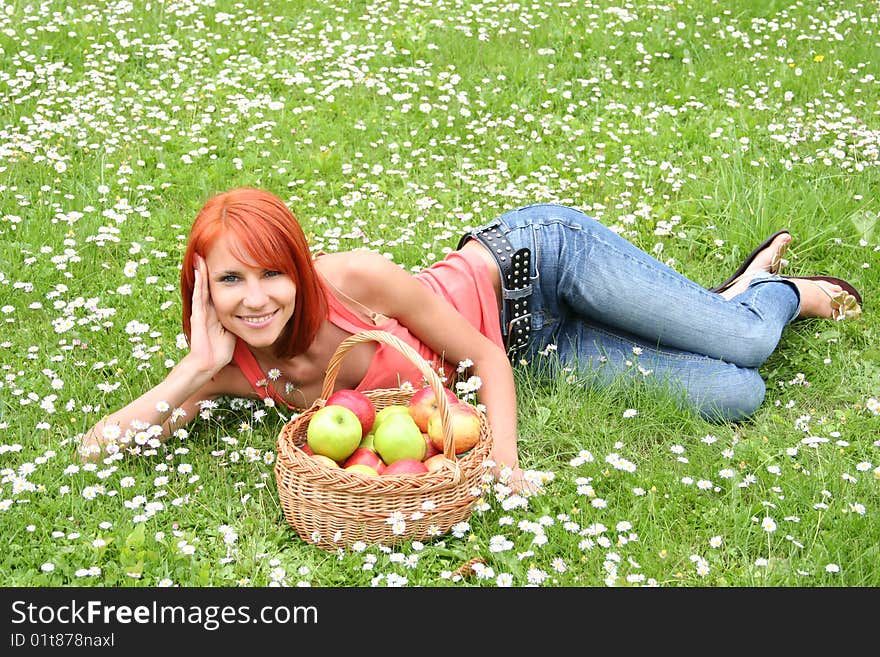 Beautiful girl with a basket of apples on a meadow. Beautiful girl with a basket of apples on a meadow