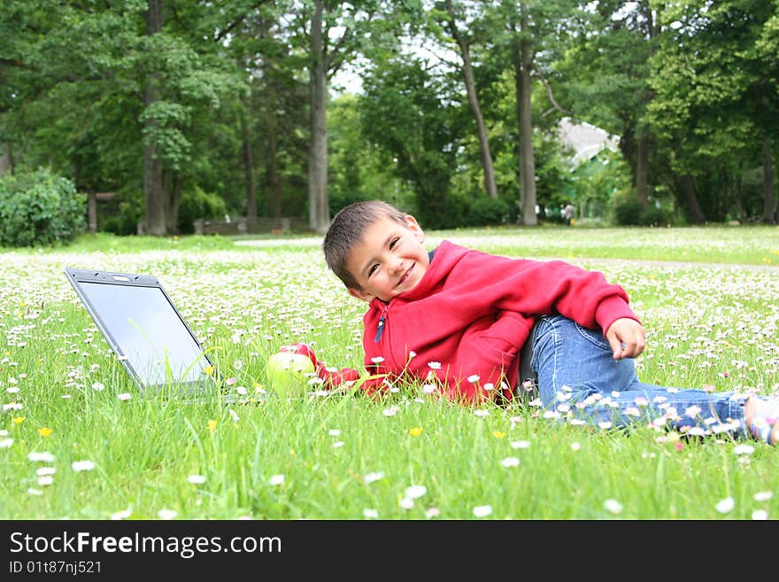 Cute little boy with laptop on a meadow. Cute little boy with laptop on a meadow