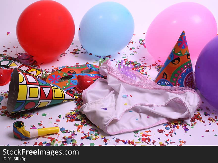 Ladies pants laying at a floor filled with party attributes, balloons and confetti. Ladies pants laying at a floor filled with party attributes, balloons and confetti