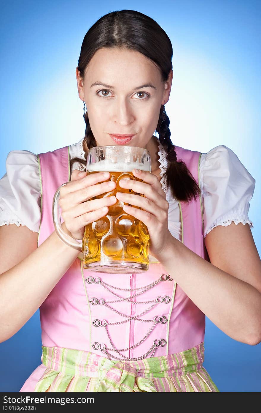 A young Bavarian girl celebrating Oktoberfest with a mass of beer. A young Bavarian girl celebrating Oktoberfest with a mass of beer