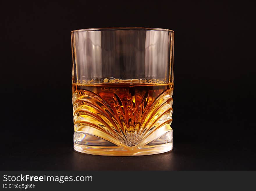 Glass with liquid on isolated black background