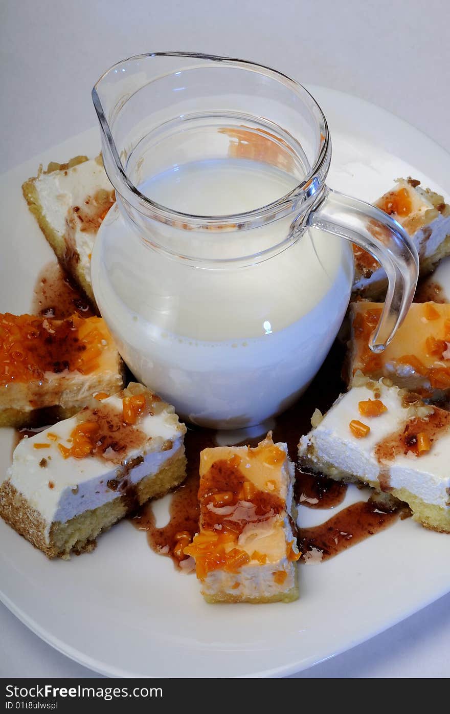 Closeup with tasty cakes on white plate and fresh milk