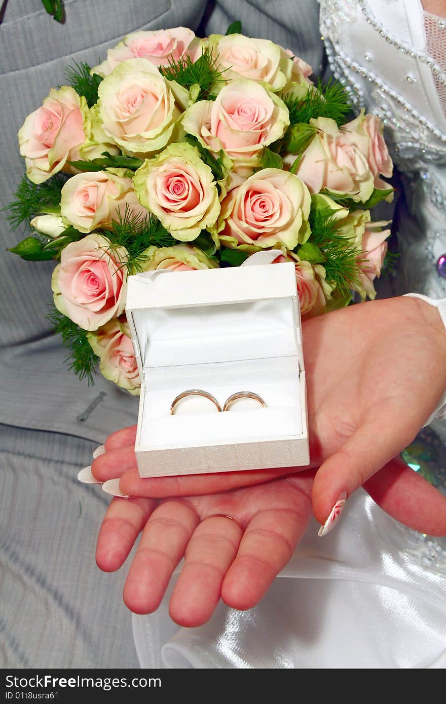 Two wedding rings in white box and bouquet for fiance and fiancee