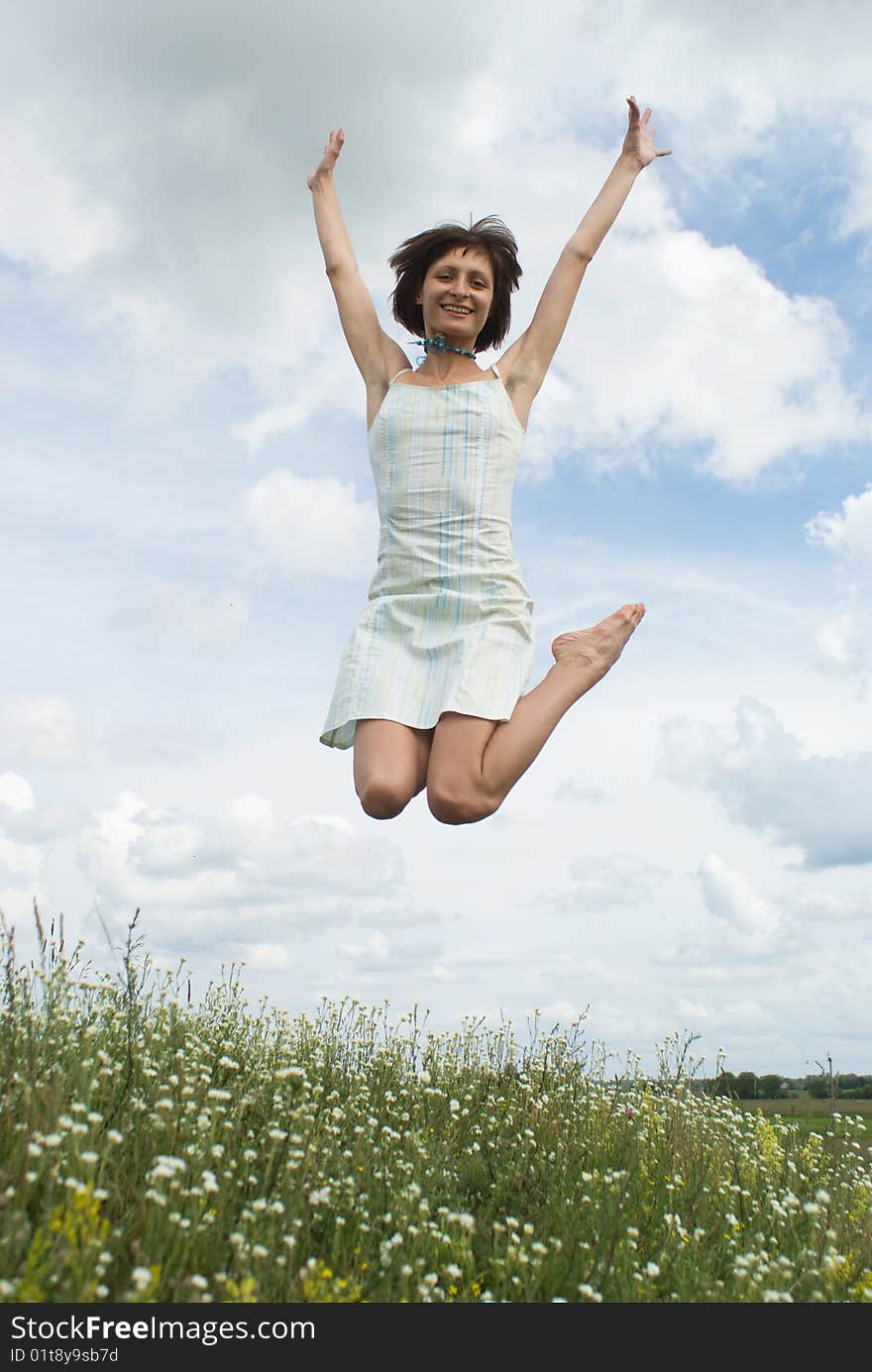 Jumping girl on the green hill (summer)