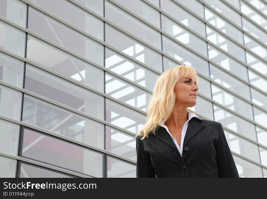 Business woman standing in front of office building. Business woman standing in front of office building.