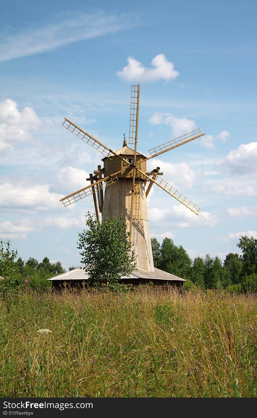 Old rural windmill and cloud in sky