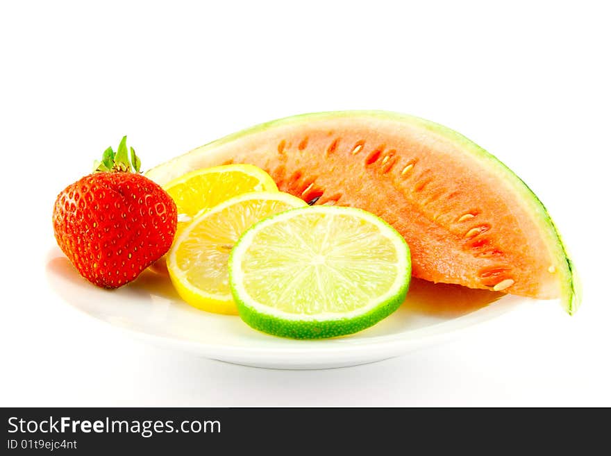 Slices of lemon, lime and orange with a ripe red strawberry and slice of juicy watermelon on a white background. Slices of lemon, lime and orange with a ripe red strawberry and slice of juicy watermelon on a white background