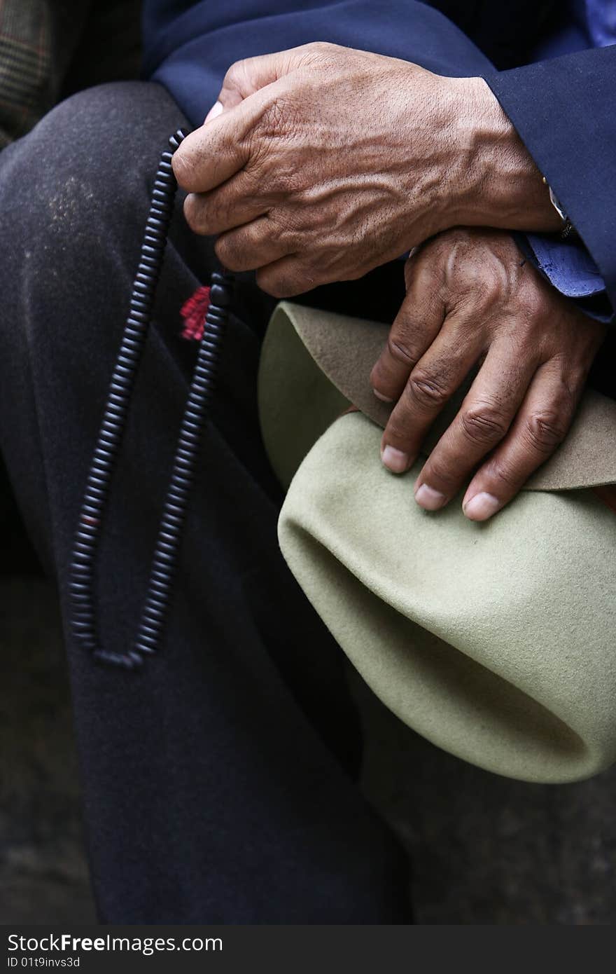 Male hands holding Buddhist beads.