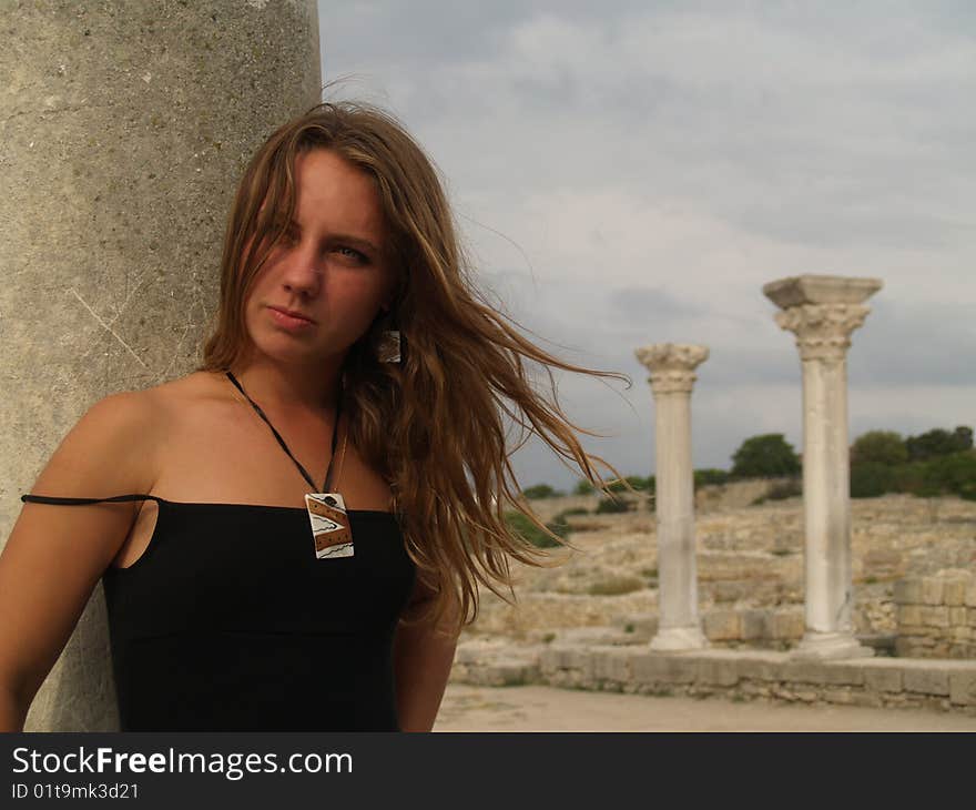 Beautiful girl in a long skirt near the columns.