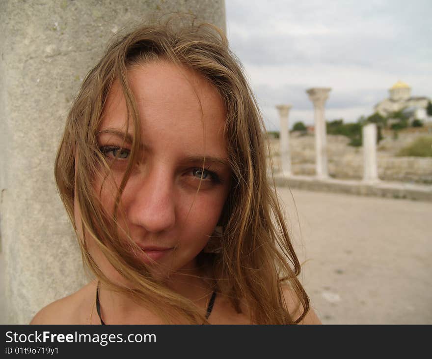 Beautiful girl in a long skirt near the columns.