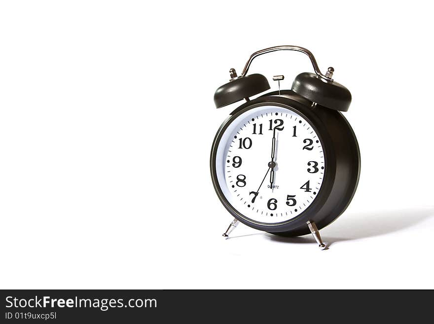 Isolated on white image of a black alarm clock showing 6 o'clock. Isolated on white image of a black alarm clock showing 6 o'clock