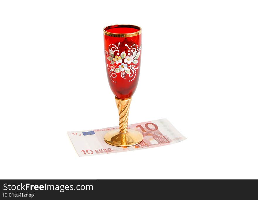 Beautiful red wine glass with golden stem on ten euro bill isolated. Beautiful red wine glass with golden stem on ten euro bill isolated