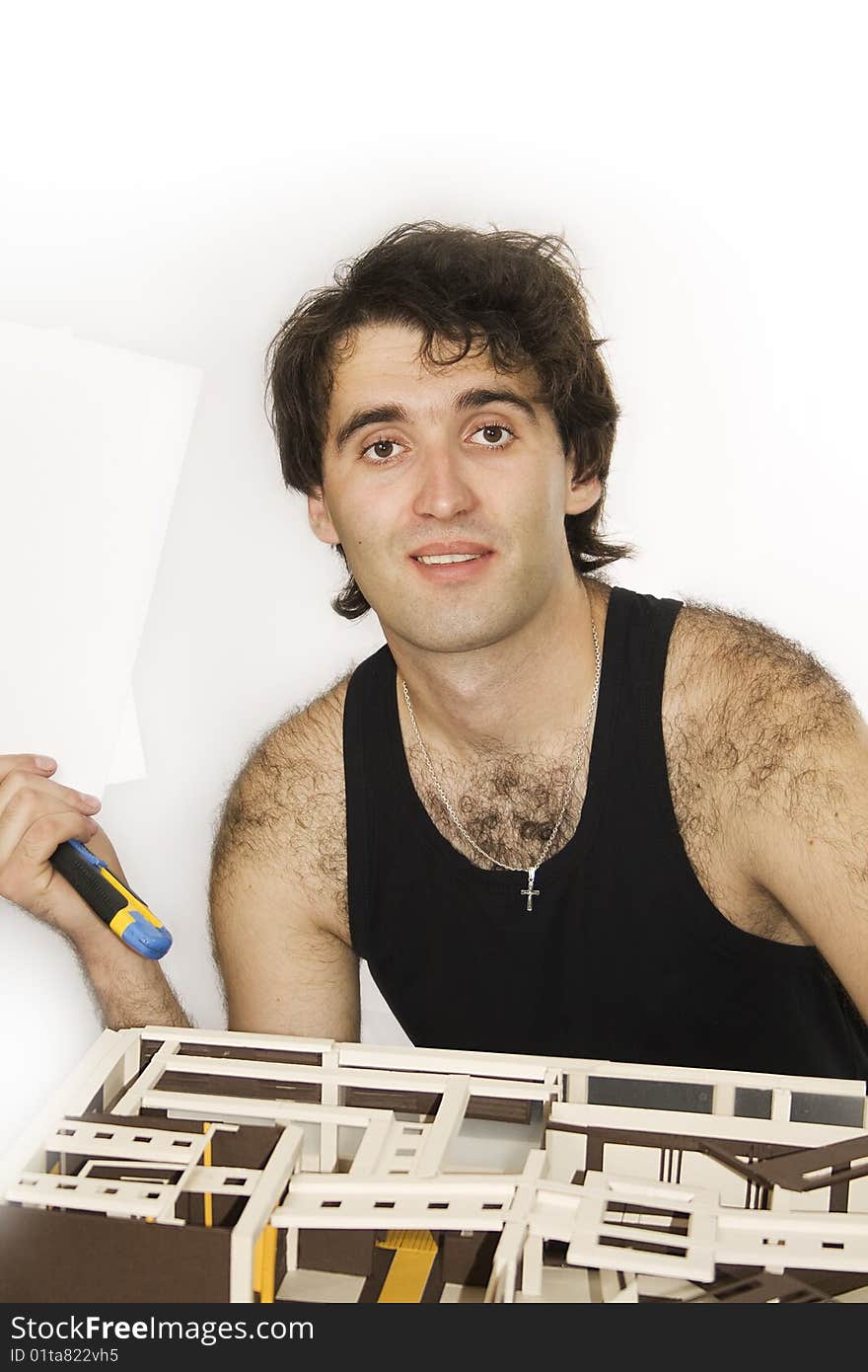 A young architect working on a model of a new construction.