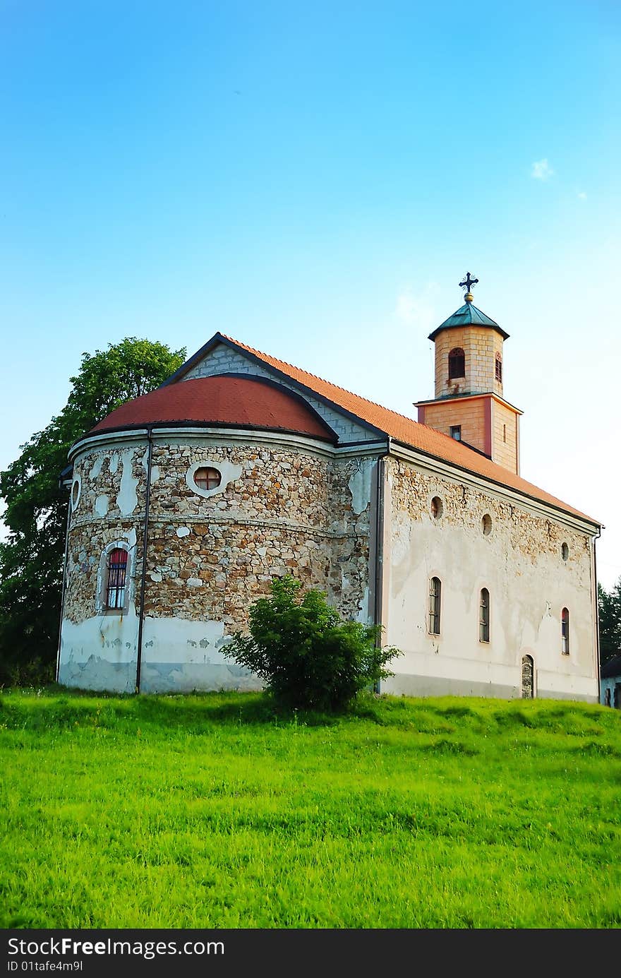 An old church on green medow with blue sky above