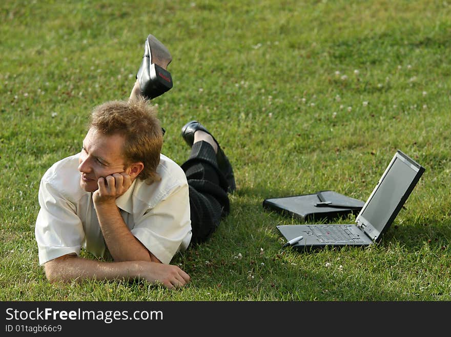 Relaxing businessman lying on the grass. Relaxing businessman lying on the grass