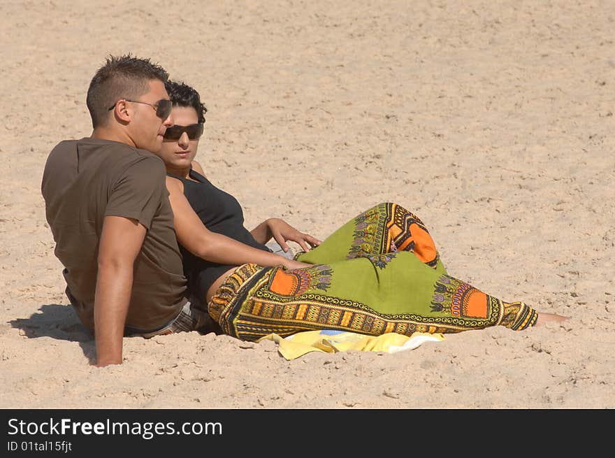 Attractive lovely couple relaxing on the beach. Attractive lovely couple relaxing on the beach