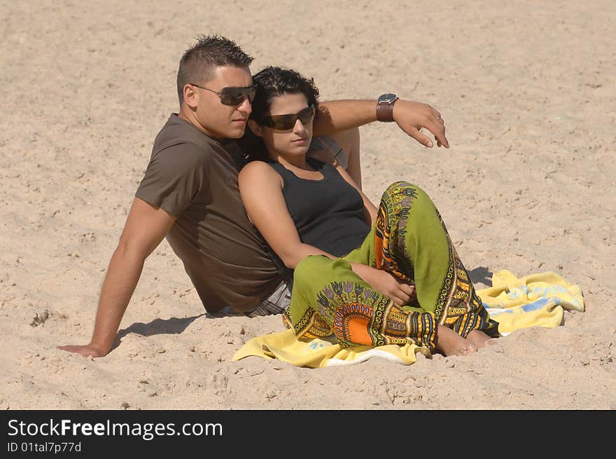 Attractive lovely couple relaxing on the beach. Attractive lovely couple relaxing on the beach