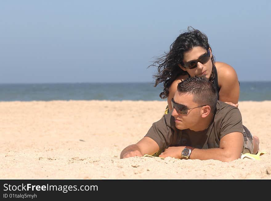 Attractive lovely couple relaxing on the beach. Attractive lovely couple relaxing on the beach