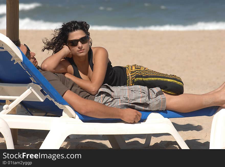 Attractive lovely couple relaxing on the beach. Attractive lovely couple relaxing on the beach