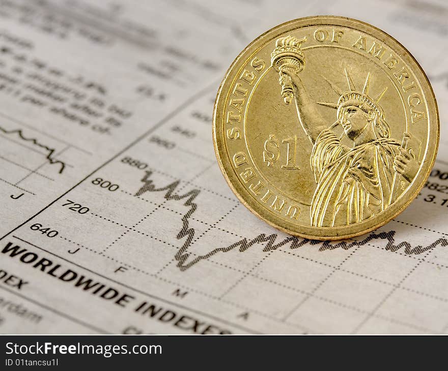 View in close up of a chart with an American coin following its line. View in close up of a chart with an American coin following its line.