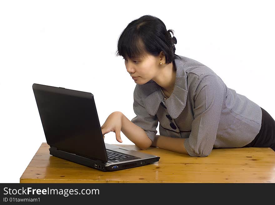 Beautiful asian business woman looking serious at her laptop on white background