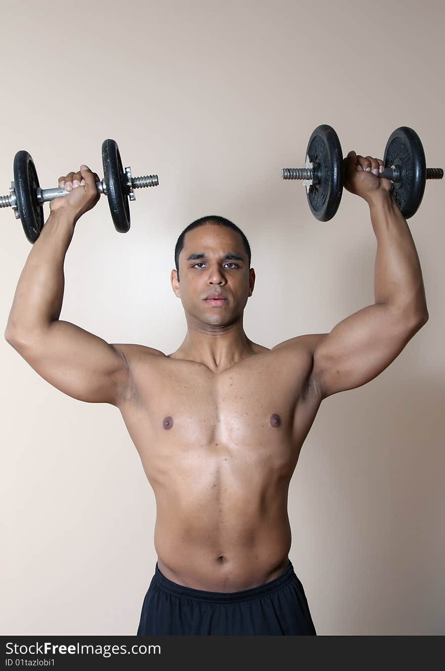 Muscular male body, lifting dumbbells