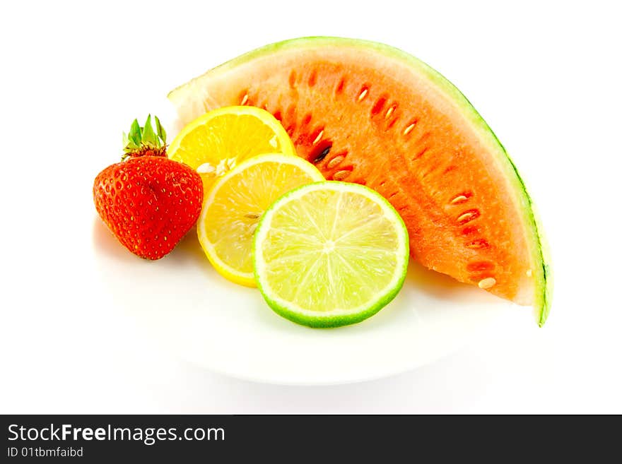 Slices of lemon, lime and orange with a ripe red strawberry and slice of juicy watermelon on a white background. Slices of lemon, lime and orange with a ripe red strawberry and slice of juicy watermelon on a white background