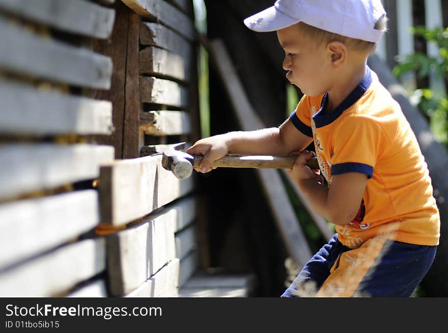 Little, cute boy playing with heavy tools