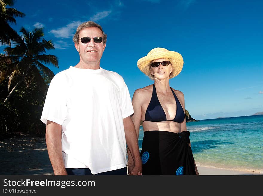 A happy mature couple poses on a tropical beach. A happy mature couple poses on a tropical beach