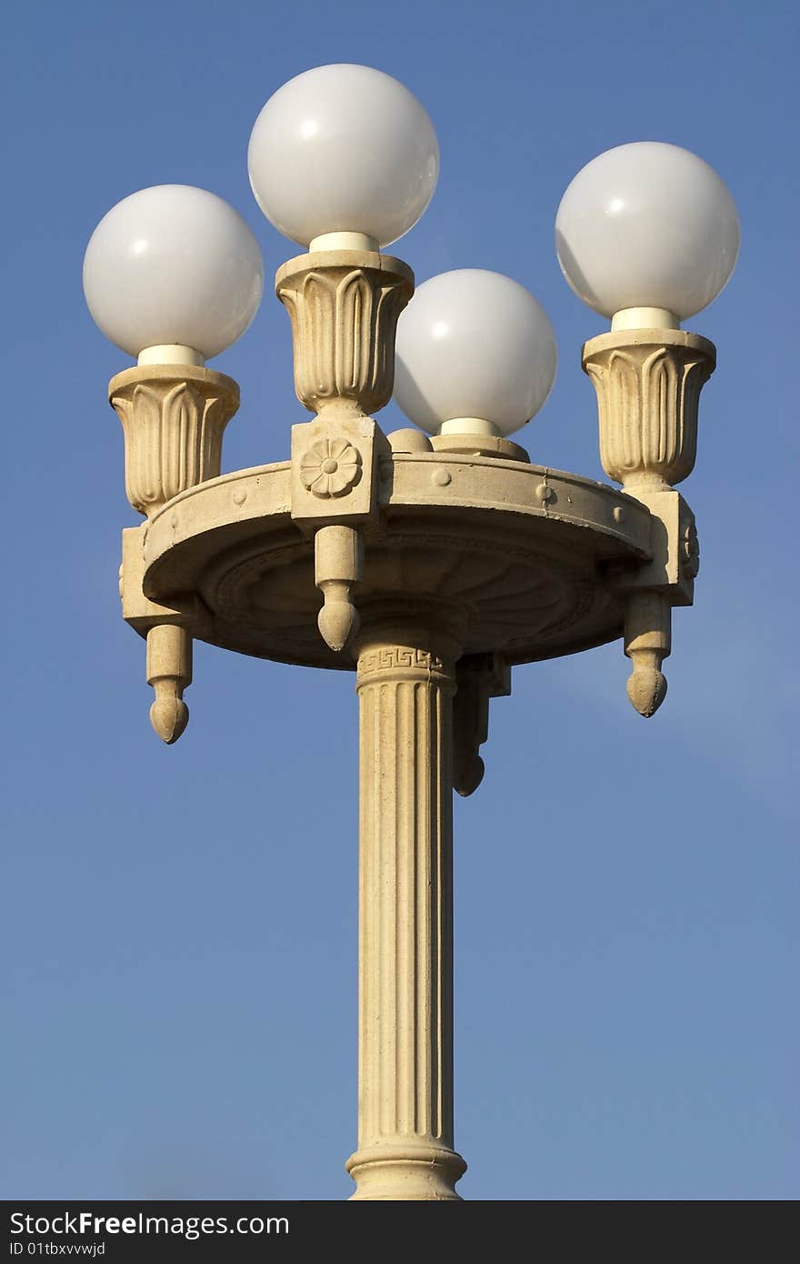 Beautiful street lamp with four matte glass balls over clear blue sky