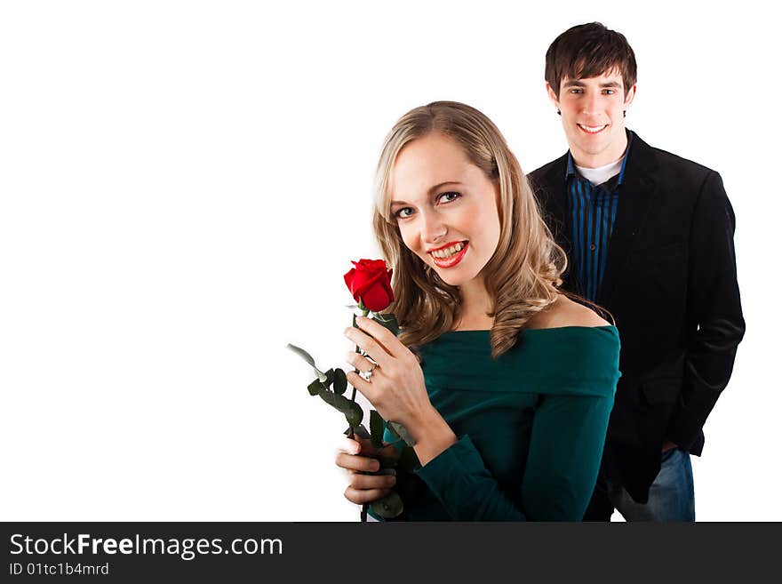 A newly engaged couple smiles at the camera. A newly engaged couple smiles at the camera