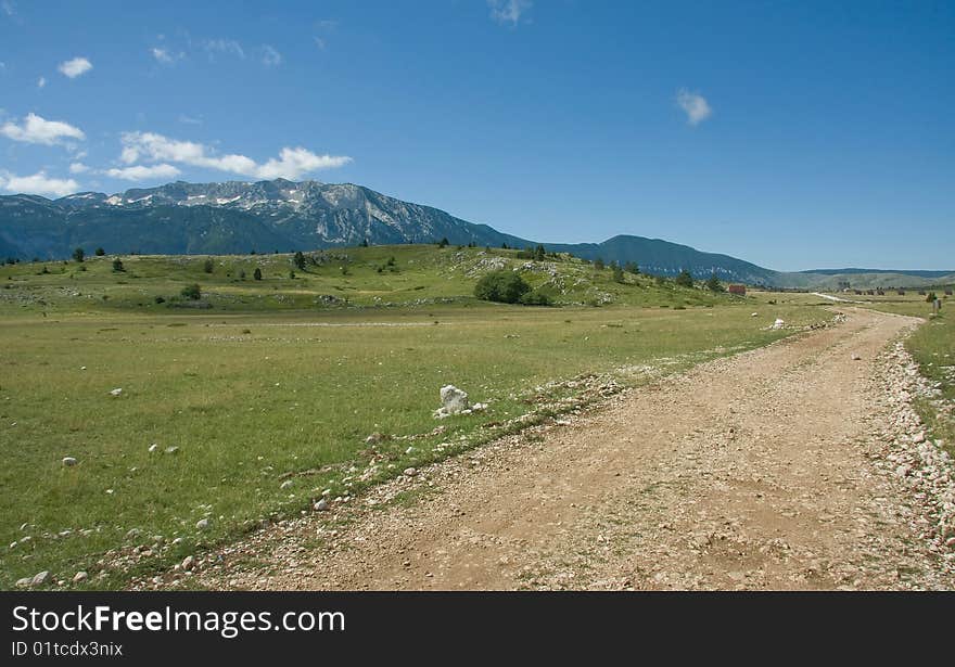 Beautiful mountains landscape, macadam road, meadows and pastures. Beautiful mountains landscape, macadam road, meadows and pastures.