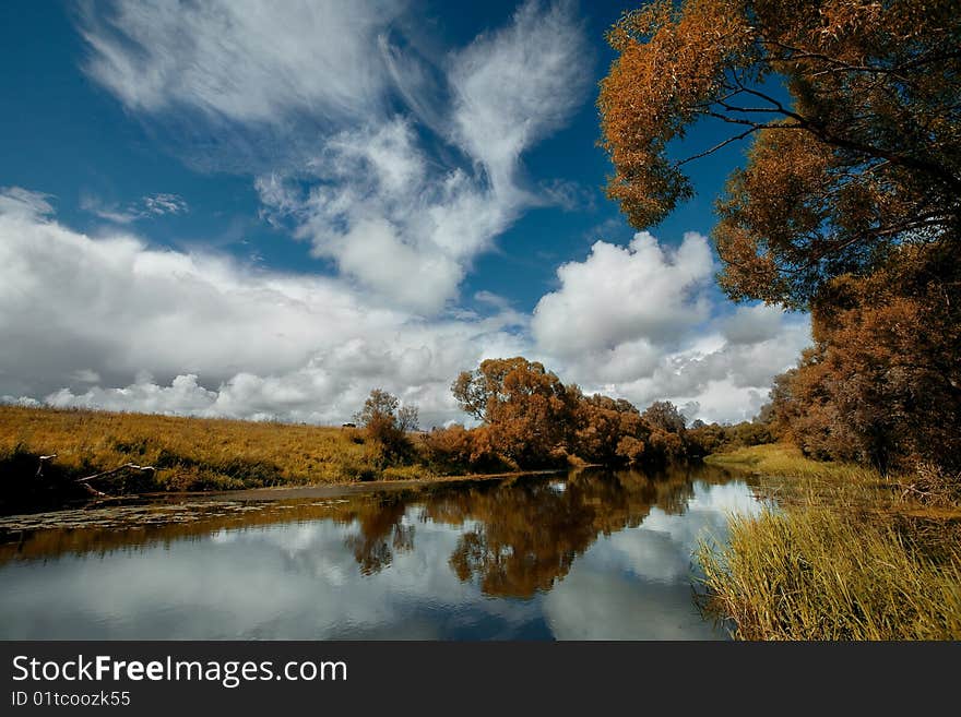 River,trees and blue sky with clouds. River,trees and blue sky with clouds.