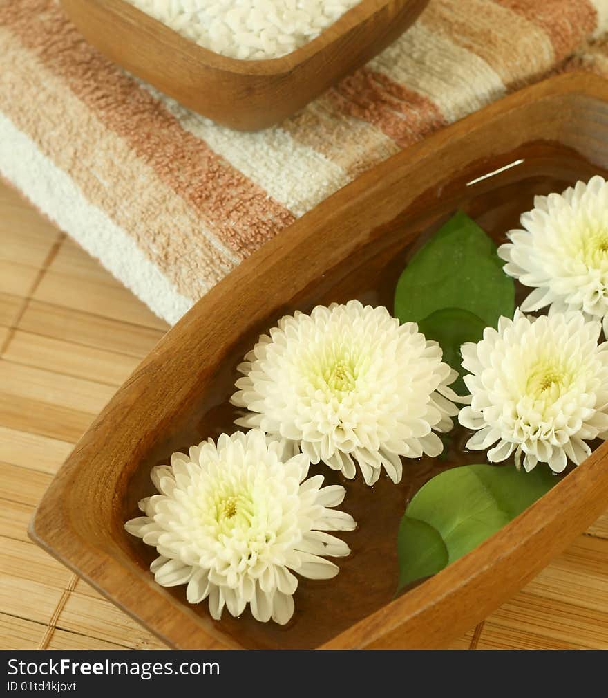 White flowers floating in wooden bowl.