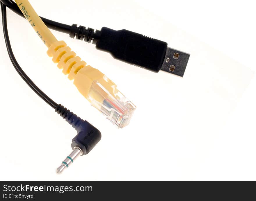 Three cables, a black USB one, a black audio one and a yellow LAN one, over a white background.