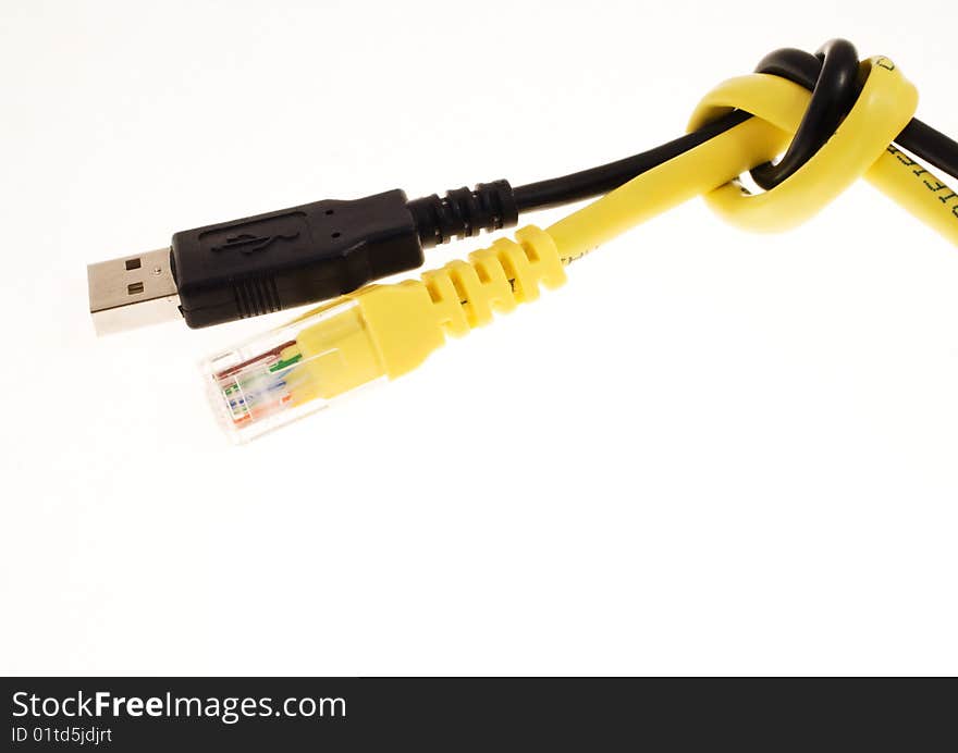 Black usb cable and yellow lan cable knotted together over a white background. Black usb cable and yellow lan cable knotted together over a white background.