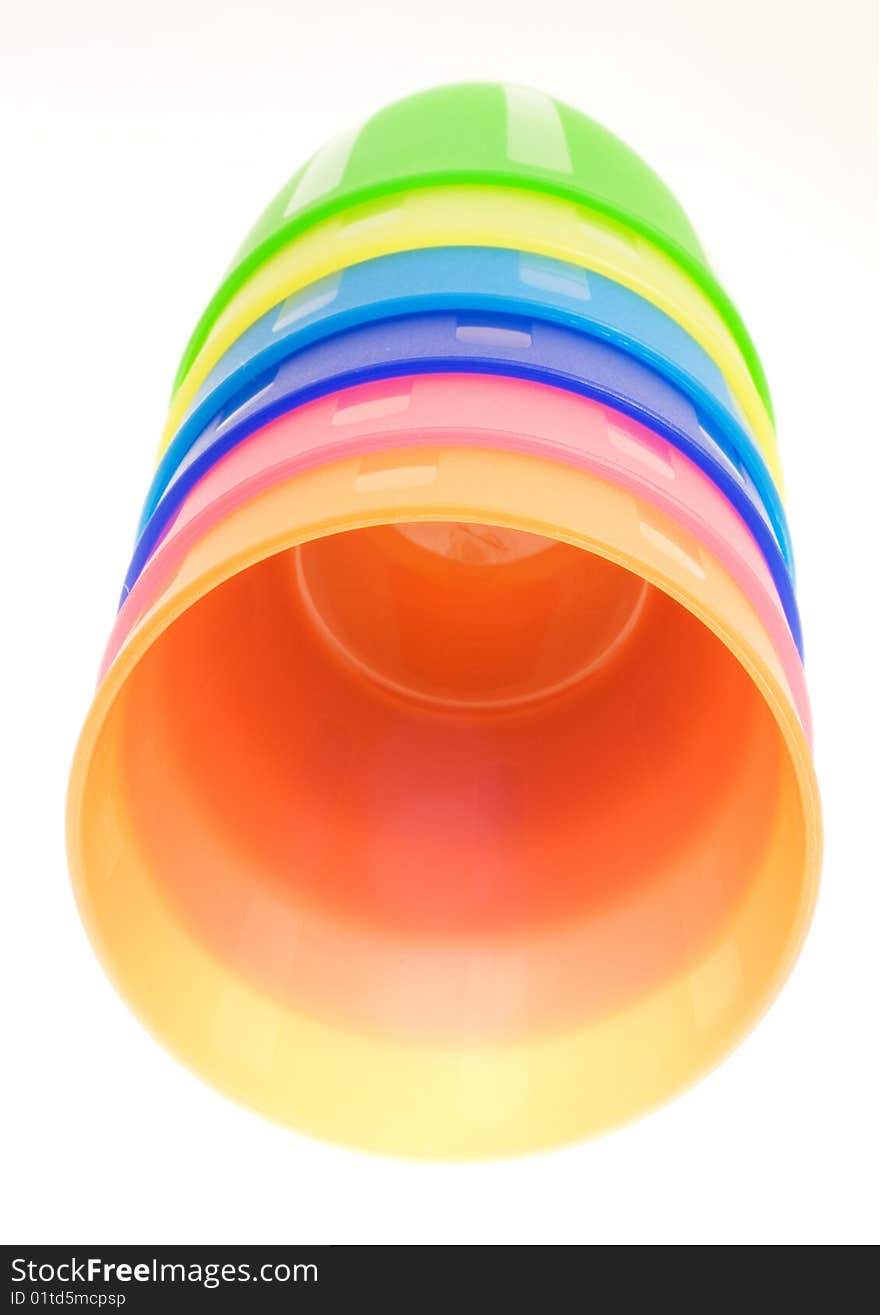 Stack of colored plastic cups lying on a white background.