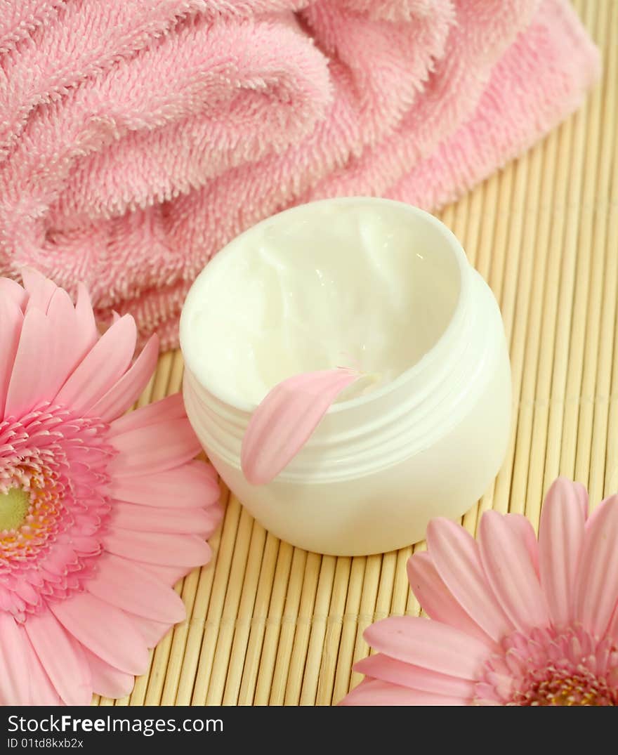 Spa essentials. Bowl of cream, pink towel and flowers. Spa essentials. Bowl of cream, pink towel and flowers.