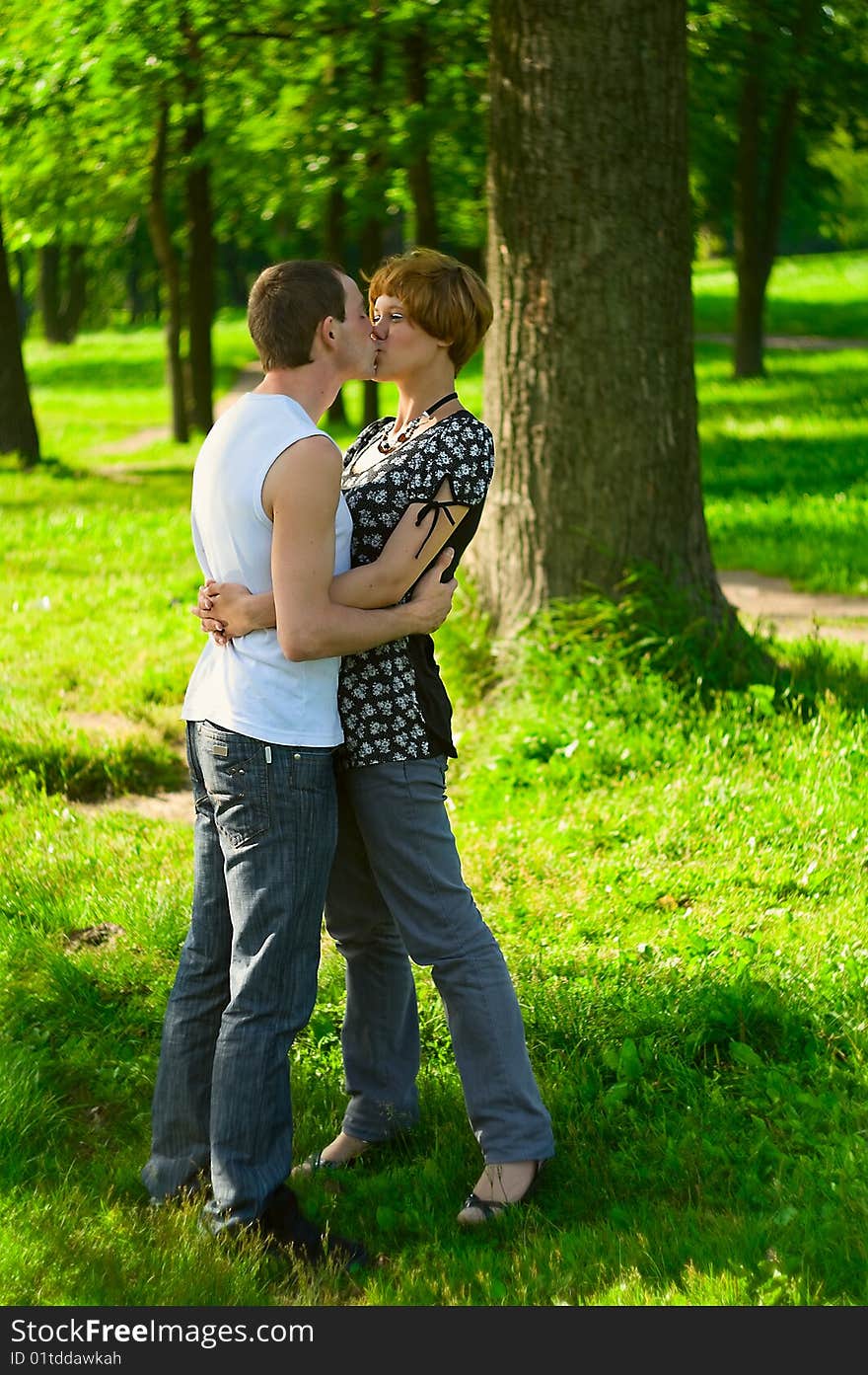 Teenagers: man is kissing girlfriend on nature. Full-length portrait. Teenagers: man is kissing girlfriend on nature. Full-length portrait