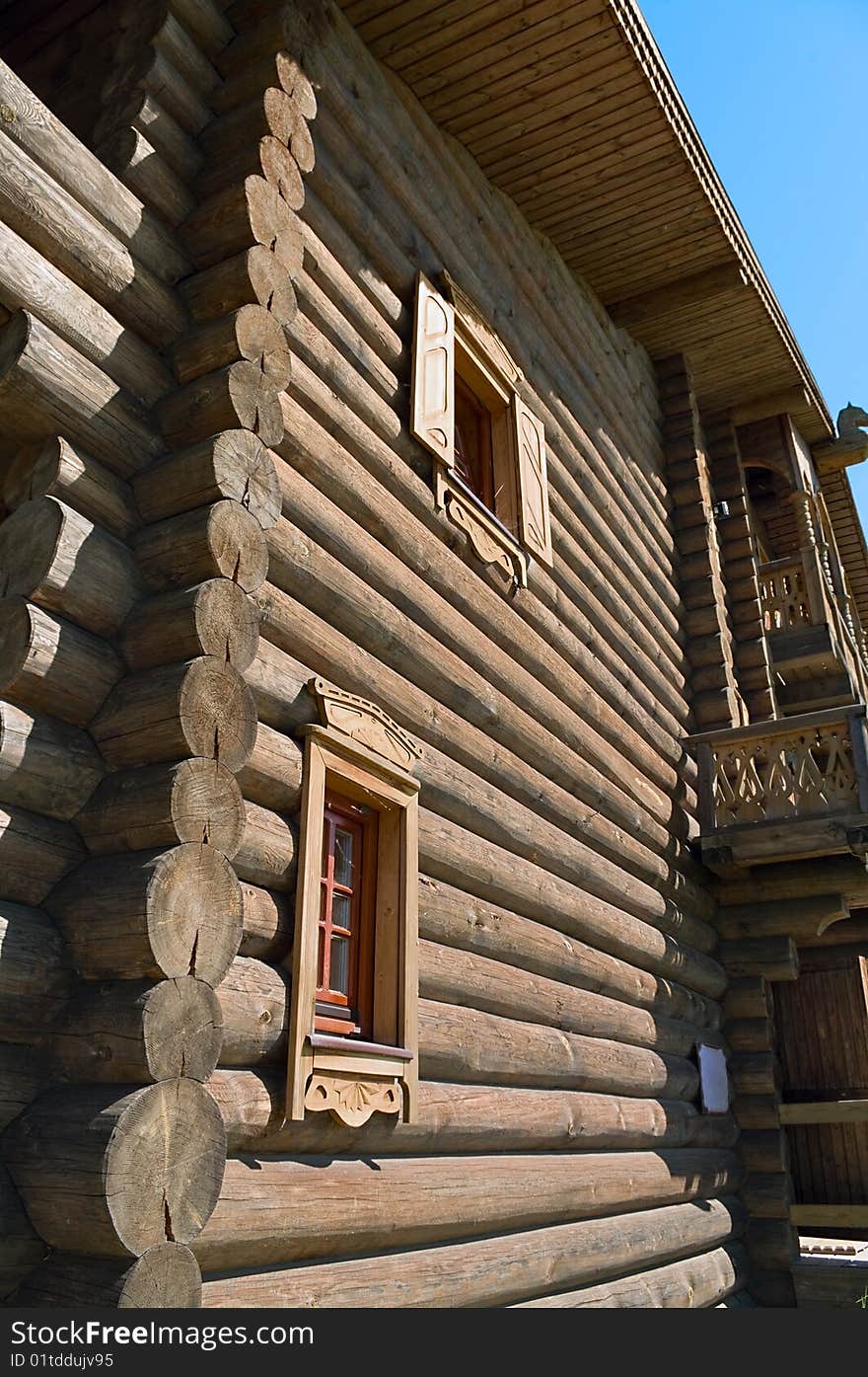 Wall of wooden big house from timbers and windows on it. It is in a village in Russia. Sunny day