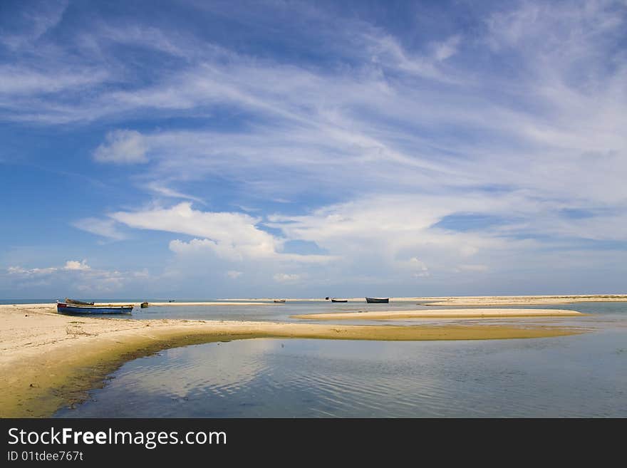 Blue sky, white clouds, boats on sandbanks, spits in a sea. Blue sky, white clouds, boats on sandbanks, spits in a sea