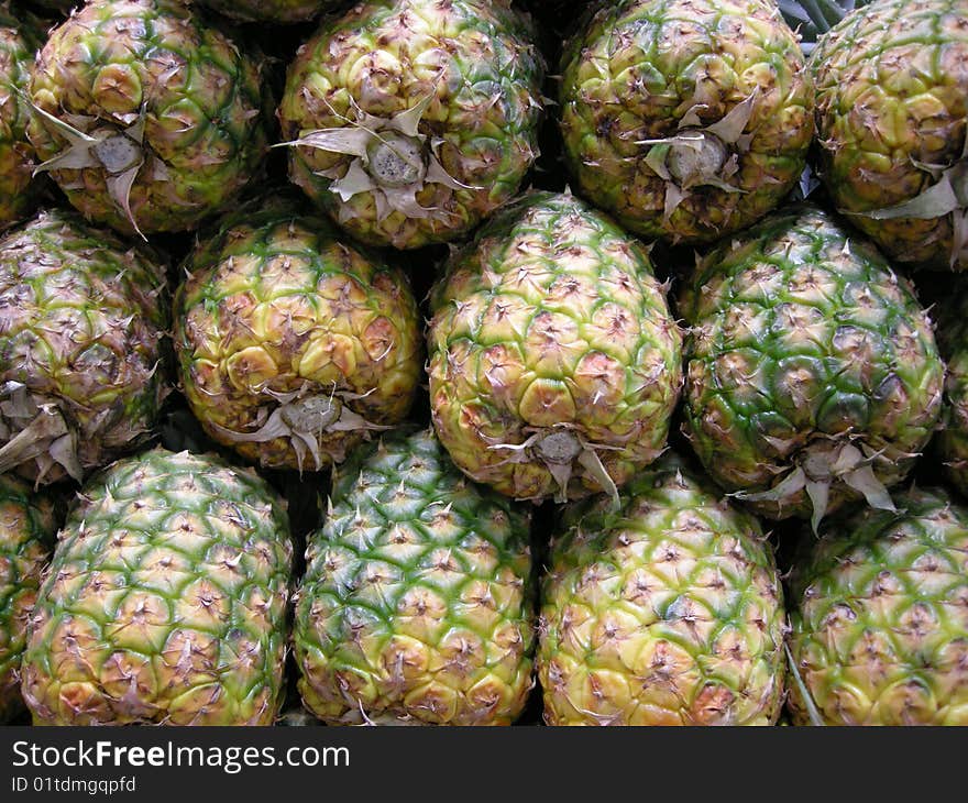 Stock photo of a stack of pineapples in a marketplace