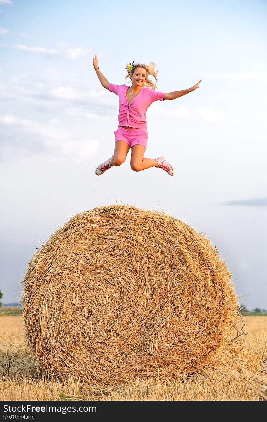 Blond girl jumping high at the field