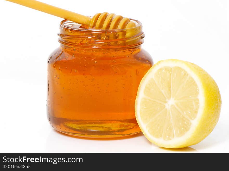 Honey jar and lemon isolated