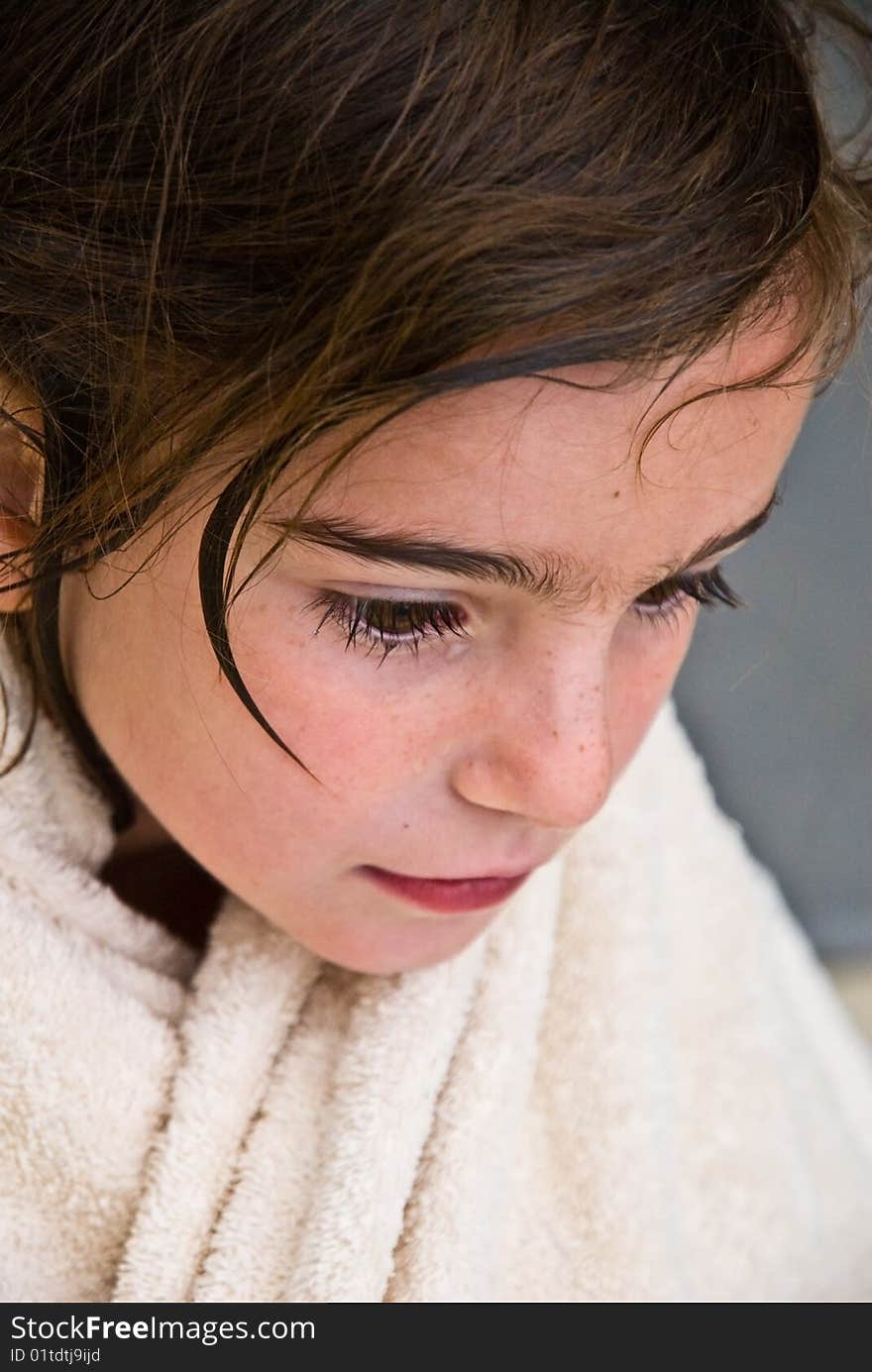 A wet young girl with a towel wrapped around her neck. ( After a bath or a swim.). A wet young girl with a towel wrapped around her neck. ( After a bath or a swim.)