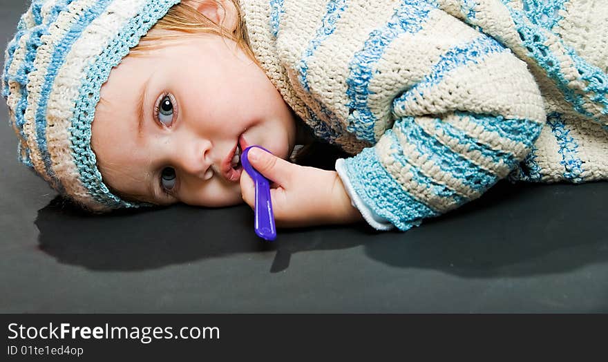 Little baby in a bound suit lies on black background. Little baby in a bound suit lies on black background