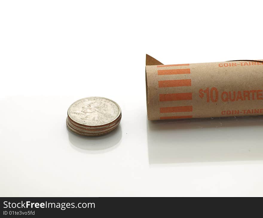 A stack of quarters outside an open quarter roll on a white bg. A stack of quarters outside an open quarter roll on a white bg.